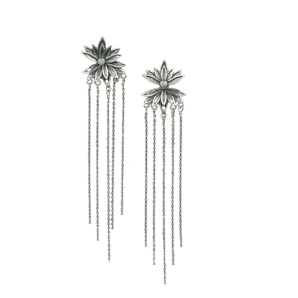 Pair of silver floral earrings with chain drops on a white background